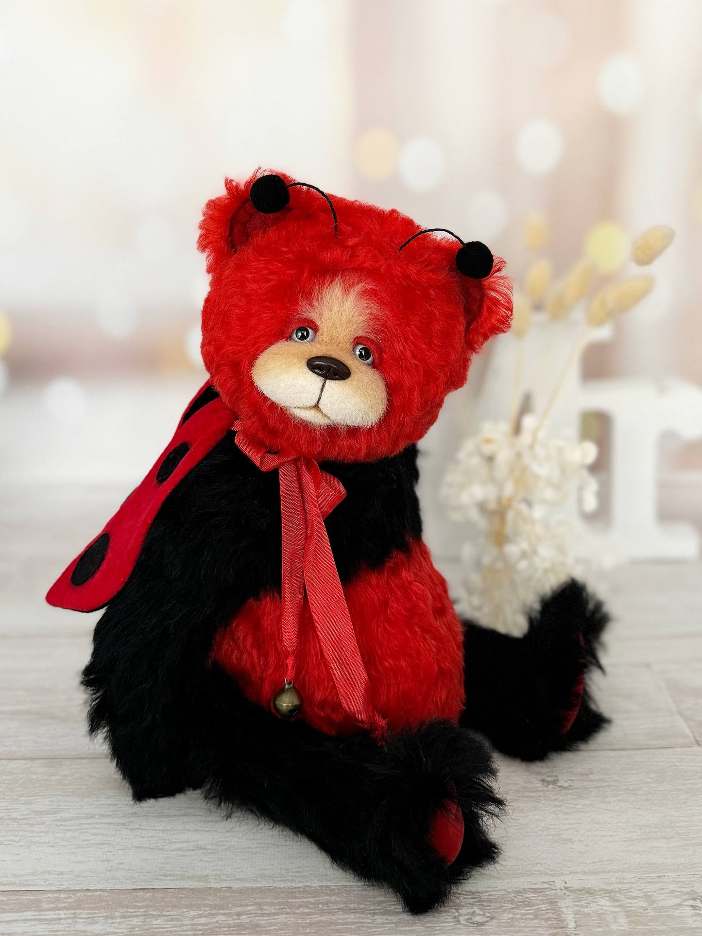 Close-up of Scarlet Ladybug Deluxe teddy bear face with gray/blue glass eyes and hand-sculpted nose